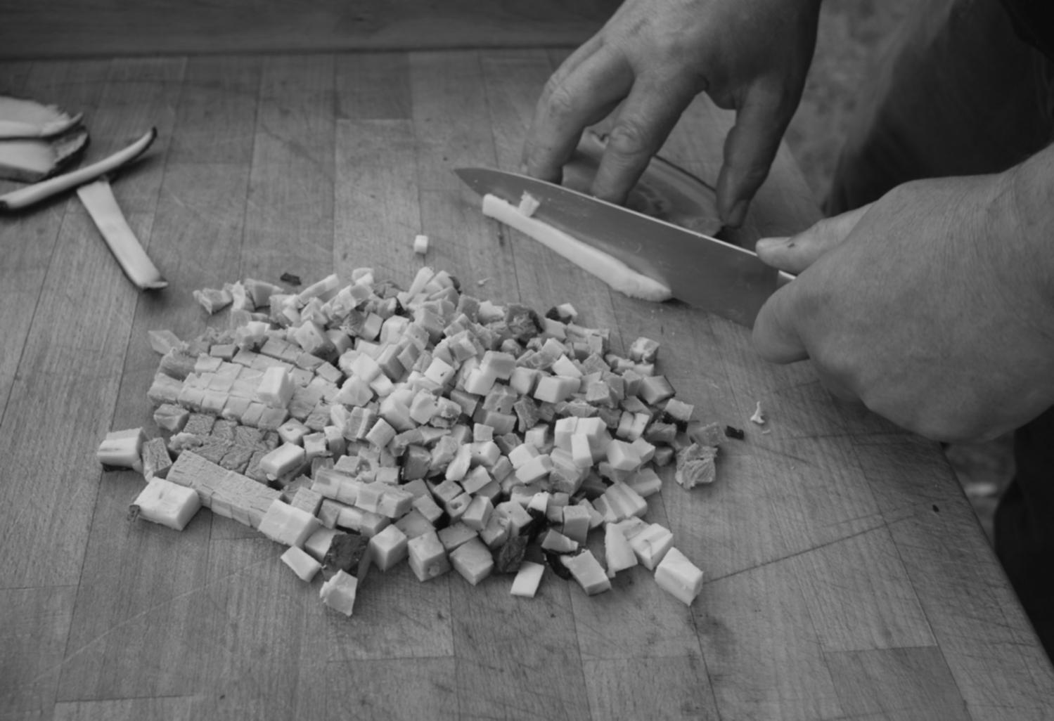 Student accessing online culinary lectures on laptop in home kitchen environment